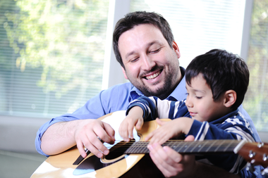 Father and son playing guitar at home sbi 300985826